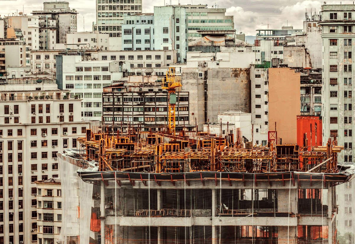 Prédio em construção com tela de proteção e guindaste no centro de São Paulo